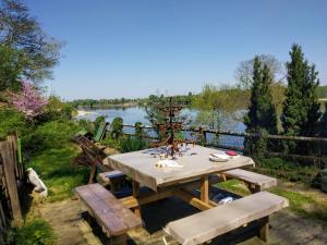 a picnic table with a view of a river at Naturellement Loire ! in Saint-Martin-de-la-Place