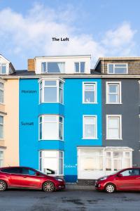 two cars parked in front of a blue building at Seabrin in Aberystwyth