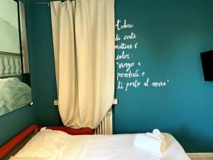 a bedroom with a bed and a wall with writing on it at Confortevole monolocale a 500 mt dal mare in Marina di Carrara