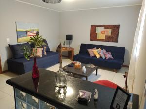 a living room with a blue couch and a table at Casa da Lu Itacoatiara -Apartamento Costão in Niterói