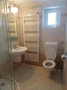 une salle de bain avec toilettes, lavabo et fenêtre dans l'établissement Rózsa Vendégház Keszthely, à Keszthely