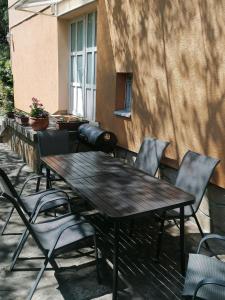 une table et des chaises en bois sur une terrasse dans l'établissement Rózsa Vendégház Keszthely, à Keszthely 19 autres photos