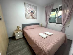 a bedroom with a bed with two towels on it at Sant Adria Beach apartment Wi-Fi Parking Free in Sant Adria de Besos
