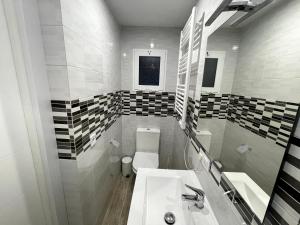 a white bathroom with a sink and a toilet at Sant Adria Beach apartment Wi-Fi Parking Free in Sant Adria de Besos