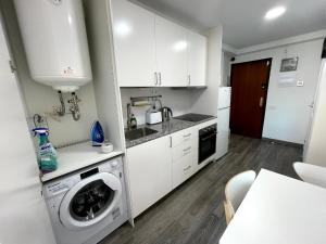 a kitchen with white cabinets and a washer at Sant Adria Beach apartment Wi-Fi Parking Free in Sant Adria de Besos +17 photos