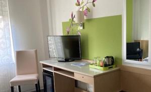 a desk with a computer monitor on top of it at Hotel Garni Sand in Tübingen