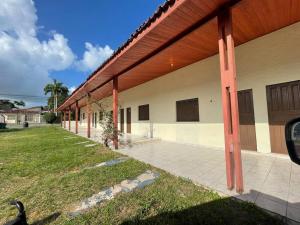 un grand bâtiment avec des poteaux rouges sur son côté dans l'établissement Pousada Bouganville Bell, à Salinópolis