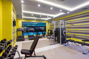 a gym with several treadmills and chairs in it at Karmir Resort & Spa - Ultra All Inclusive in Kemer