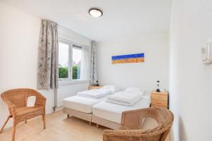 1 dormitorio con 1 cama, 2 sillas y ventana en Hello Zeeland - Vakantiehuis Schelde 194, en Breskens