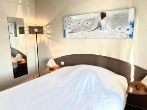 - une chambre avec un lit blanc et une peinture murale dans l'établissement Hôtel - Restaurant "Histoire de Bistrot", à Isbergues