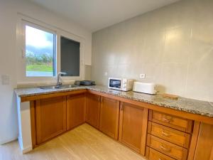 a kitchen with a counter with a sink and a microwave at Baía dos Moinhos in Ribeira Grande