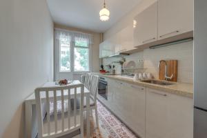 uma cozinha branca com armários brancos e um lavatório em Beautiful Jewel in Top Center em Sófia