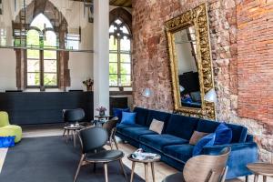 a living room with a blue couch and a brick wall at Kloster Hornbach in Hornbach