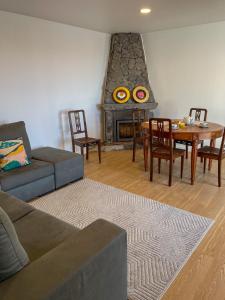 a living room with a couch and a table and a fireplace at Baía dos Moinhos in Ribeira Grande