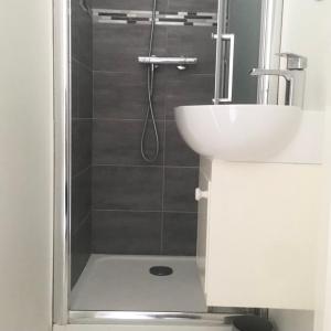 een badkamer met een douche en een wastafel bij Cristal House in Trouville-sur-Mer