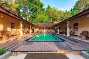 una piscina cubierta en una casa con terraza de madera en Hanthana Boutique Villa by Amaya en Kandy