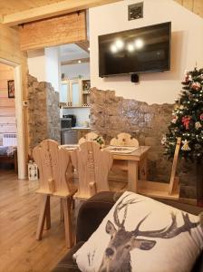 a living room with a tv and a christmas tree at Apartament w Zagrodzie in Frydman