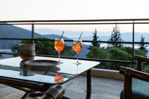 two wine glasses sitting on a table on a balcony at Amalia Hotel Delphi in Delfoi