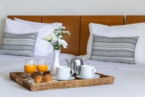 a tray with breakfast foods and juice on a bed at Amalia Hotel Delphi in Delfoi