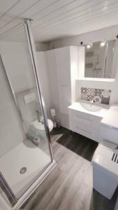 a white bathroom with a shower and a sink at Joli T2 avec clim, 4/6 personnes,500m de la plage. in Saint-Cyprien