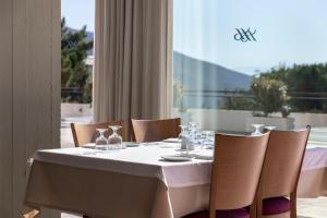 a table with a white table cloth and chairs and a window at Amalia Hotel Delphi in Delfoi
