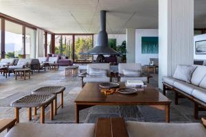 a living room with couches and a table and chairs at Amalia Hotel Delphi in Delfoi