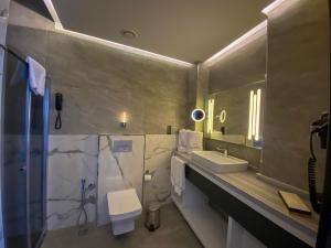La salle de bains est pourvue d'un lavabo, de toilettes et d'une douche. dans l'établissement Aileena Hotel & Villas, à Kartepe
