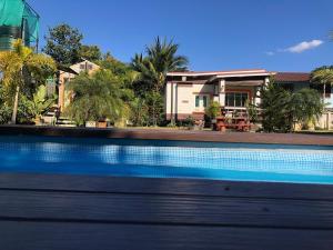 a house with a swimming pool in front of a house at มุกดาสวรรค์ รีสอร์ท - Mukda Sawan Resort in Mukdahan