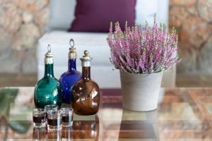 a table with three bottles and a vase with flowers at Amalia Hotel Delphi in Delfoi