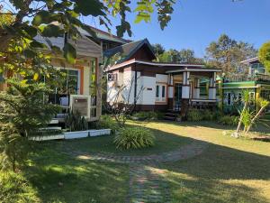 une maison avec un jardin en face dans l'établissement มุกดาสวรรค์ รีสอร์ท - Mukda Sawan Resort, à Mukdahan