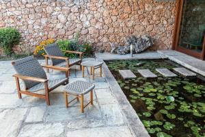 a patio with two chairs and a pond with lilies at Amalia Hotel Delphi in Delfoi