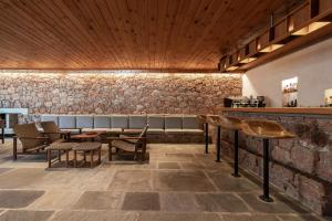 a large room with a stone wall and wooden floors at Amalia Hotel Delphi in Delphi