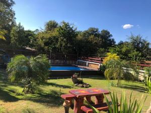 - une table de pique-nique dans une cour avec une piscine dans l'établissement มุกดาสวรรค์ รีสอร์ท - Mukda Sawan Resort, à Mukdahan