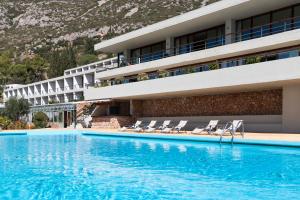a swimming pool with a balcony overlooking the ocean at Amalia Hotel Delphi in Delphi