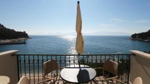 einen Tisch und Stühle auf einem Balkon mit Blick auf das Wasser in der Unterkunft Apartments on the beach-Drvenik in Drvenik