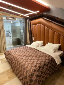 Hotel Havana Loznica في لوزنيكا: غرفة نوم بسرير كبير مع اللوح الخشبي