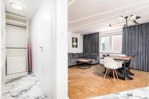 a dining room and living room with a table and a couch at Apartament One by Your Freedom in Warsaw
