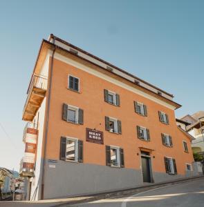 un gran edificio naranja al lado de una calle en Stalder Meat & Bed en Muralto