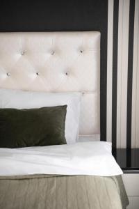 a bedroom with a white bed with a black and white striped wall at RentWill apartments Black&White in Chişinău