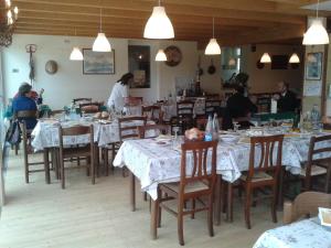 a restaurant with tables and chairs with people sitting at them at Agriturismo Villa Brugolta in Lavena Ponte Tresa +31 photos