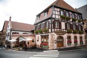 a building with flower boxes on the front of a street at Appartements Le Hupsa Pfannala in Saint-Hippolyte