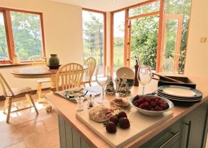 una cocina con una mesa con una bandeja de comida y copas de vino en Anglers Retreat en Brechin