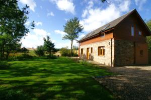 a small brick building in a grassy yard at Anglers Retreat in Brechin