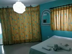 璜多里奧的住宿－condominio albatros mar caribe，一间卧室配有一张床、镜子和灯