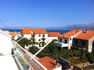 a group of houses with red roofs and the water at Villa Radoš - 4 Sterne, 3 Apartments für maximal 18 Gäste in Supetar