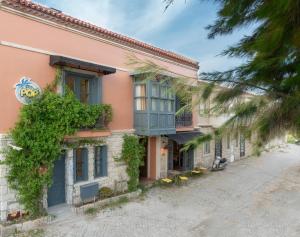 a pink building with blue windows and plants at Hotel Pop Alaçatı in Alaçatı