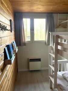 1 dormitorio con litera y ventana en Familie Meys Chalets - Chalet 236 - La Boverie, en Rendeux