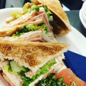 Un sándwich se corta por la mitad en un plato en Woodsome Hall Golf Club Dormy House en Fenay Bridge