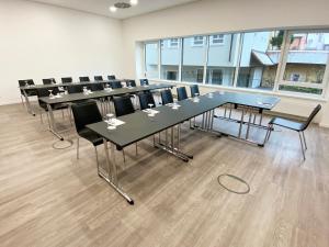 una sala de conferencias con mesas y sillas largas en DORMERO Hotel Hersbruck, en Hersbruck