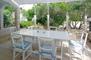 een witte tafel met vier stoelen en een paraplu bij Holiday house in Tri Porte Potirna with sea view, terrace, air conditioning, WiFi 166-1 in Potirna
